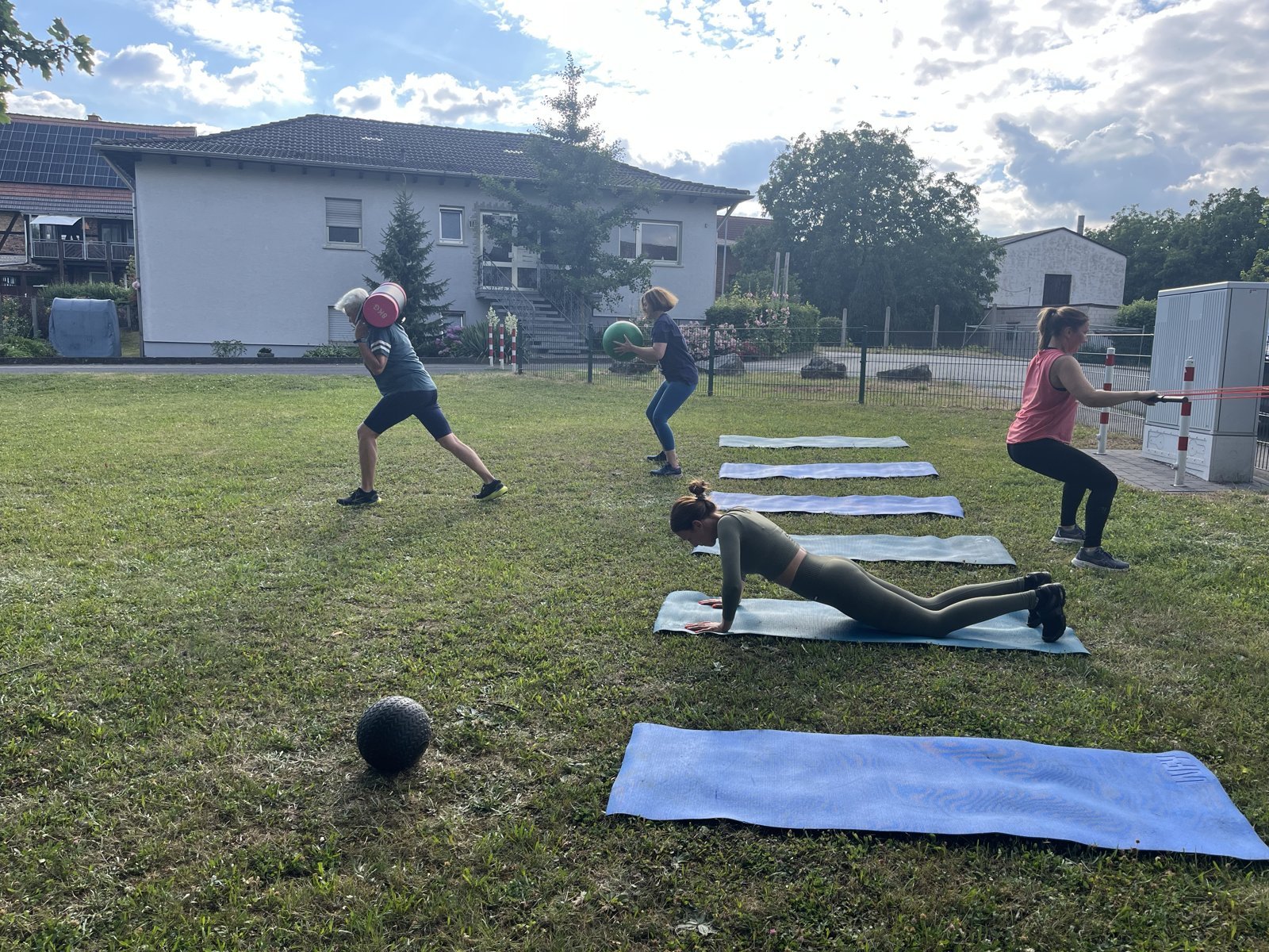 OutFit im Garten: Medizinball, Liegestütz und Kniebeuge auf Matten
